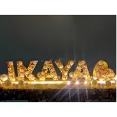 Light up your love. This customized resin LED name stand is crafted using real varmala flowers. It's a perfect blend of sentiment and art, illuminating not just a name, but precious memories.
