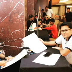 A sketch artist proudly displays his work at a corporate get-together. Booking interactive artists like these adds a dynamic and personal touch to any event, ensuring guests feel engaged and entertained throughout.
