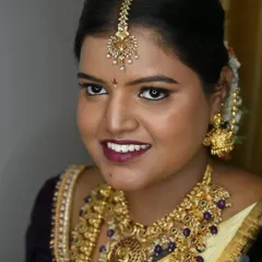 A radiant smile completes the look. My bride Sugandhi looks gorgeous with her bold lip, shimmering gold eyeshadow, and traditional jewellery for her South Indian wedding ceremony.