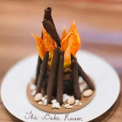My special dessert for Lohri, designed to look like a bonfire. It features chocolate sticks as logs and edible sugar work as flames, with a nutty base of sesame and jaggery.