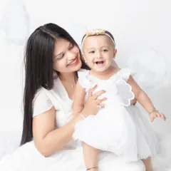 The pure joy and laughter between a mother and her baby girl, dressed as little angels.