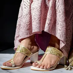 A lifestyle footwear shoot that places the product in a real-world context. The focus is on the intricate details of the sandal while showing how it complements an outfit, making it more desirable for the customer.