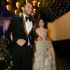 A moment of pure joy and motion. I use a slow shutter speed to capture the energy of the couple's entrance, with light trails painting a picture of their happiness.