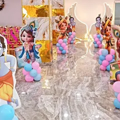 Themed cutouts of Lord Krishna lining the aisle at a naming ceremony. These small details add to the overall festive and spiritual atmosphere of the event, welcoming guests into the celebration space.