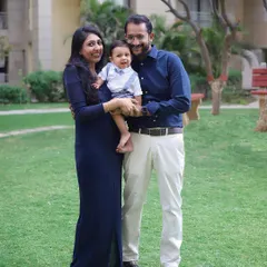 A happy family enjoying a beautiful day outside. Outdoor family photoshoots are perfect for capturing natural smiles and relaxed poses in a lovely green setting.