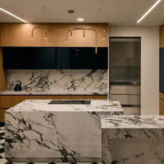 For this Bangalore kitchen, we went for a bold and classic look. A striking black and white marble island is the centerpiece, complemented by black and white checkered flooring. To add warmth, we used wood veneer cabinets and finished the space with modern gold pipe-style lights.