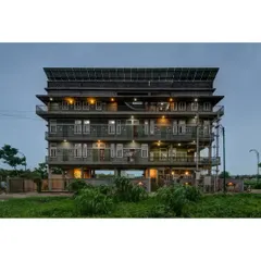The Action for Social Advancement (ASA) office in Bhopal, illuminated at night. The building is elevated on stilts to handle a water-logged site, and the rooftop is covered with a 20kVA solar PV system, making it energy self-sufficient.