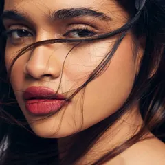 A classic look featuring a bold red lip on beautifully prepped, glowing skin. This close-up shot shows how a flawless base can make any lip color look even more stunning.