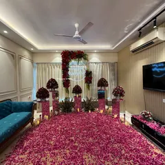 We can transform any living room into a breathtakingly romantic space. This surprise proposal decoration features a floor completely covered in thousands of red and pink rose petals, a floral arch with a custom neon sign, and elegant bouquets on mirrored pedestals.