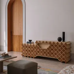 This is 'Brutus,' our handcrafted TV unit. The design features a repeating circular pattern inlaid into the wood, with a unique scalloped profile. It’s a piece that hides technology behind a beautiful, sculptural facade.