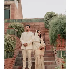 A classic full-length portrait of the couple on a brick staircase, the natural greenery and architecture providing a beautiful, rustic backdrop.