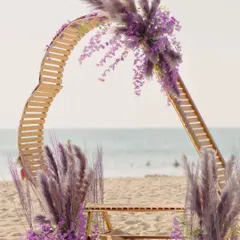 A modern, deconstructed mandap on the beach, using bent wood and pampas grass. This is for the couple who wants a unique, artistic focal point for their seaside ceremony.