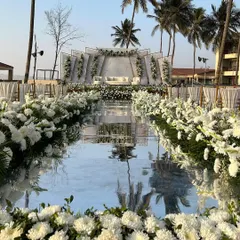 For this beachside wedding, I designed a stunning mirrored aisle that reflects the sky and the elegant white floral decor. This modern setup, with its clean lines and backdrop of palm trees, creates a serene and luxurious path for the couple's grand entrance.