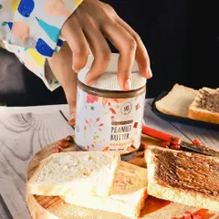 Another lifestyle shot for the peanut butter brand, this time with a hand reaching for the jar. This creates a sense of action and desire, making the product feel more dynamic and appealing.
