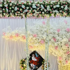 We can incorporate personal photos into the decor. Here, we placed a cherished photo of the baby within a beautiful backdrop of white and pink cherry blossoms, creating a sweet and personal focal point.