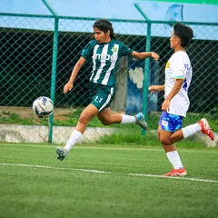 A player makes a powerful run with the ball, showcasing her speed and determination during a rainy Matchday 5 fixture.