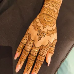 A stunning back-hand design with a scalloped edge and a mandala-like center. The fingers are adorned with a mix of net and band patterns, creating a very full and traditional look.