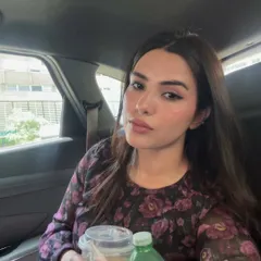 A selfie from the back of a car, holding my daily iced coffee.