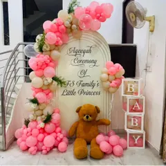 I create beautiful and respectful decorations for religious ceremonies, like this Aqeeqah for a family's 'Little Princess'. The setup includes a personalized arched backdrop, a soft pink and white balloon garland, and classic props like a teddy bear and 'BABY' blocks.