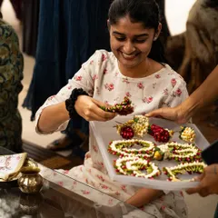 A participant at our workshop, smiling as she works with handcrafted floral jewelry. It was a joy to see so many creative minds exploring the art of traditional styling.