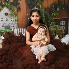 A tender moment between two sisters. The older sister holds her baby sister, creating a portrait filled with love, care, and the promise of a lifelong friendship.