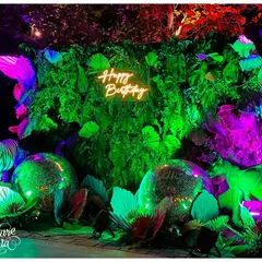 A full view of the 'Happy Birthday' photo booth. I layered neon-lit animal props, disco balls, and a wall of tropical leaves to create a dynamic and textured backdrop that glowed under the party lights.