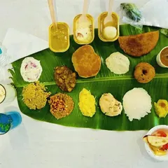 A Caterer's Meal Plate: A full spread of our delicious offerings on a banana leaf. This plate shows a variety of items including vada, payasam, kosambari, and different rice dishes.