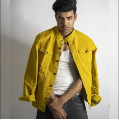 A confident and direct studio portrait. The simple styling with a white tank and yellow jacket creates a clean, modern look that is very versatile.