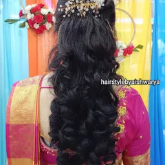 A classic half-up hairstyle with soft, bouncy curls at the ends. The look is finished with a sparkling hair accessory, perfect for an evening function.