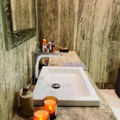 A close-up of the silver travertine marble used in this bathroom. The natural, earthy pattern of the stone adds texture and a sense of calm, complemented by simple decor like scented candles for a spa-like ambiance.