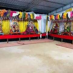 A closer view of the festival stage, showing the individual deity setups with vibrant yellow backdrops and colorful floral arrangements.