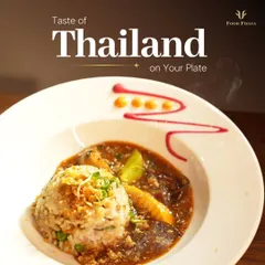 A taste of Thailand on your plate. This dish features fragrant rice with a savory Thai curry, garnished with fried onions and artistically plated to be as beautiful as it is delicious.