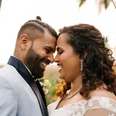The warm, golden hour light adds to the romance of this candid shot of a newly married couple. The genuine smiles and laughter are what make these wedding portraits so special.