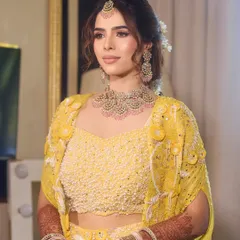 Another angle of this stunning Haldi look. The elegant updo is adorned with a flower, adding a touch of freshness and tradition.