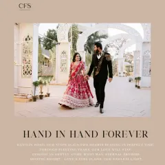 Hand in hand, this couple walks toward their future. This grand shot at a beautiful venue showcases the bride's stunning red lehenga and the groom's coordinated suit, perfect for a big fat Indian wedding album.