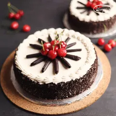 This is our classic Black Forest Cake, a crowd pleaser for generations. We layer soft chocolate sponge with fresh cream and cherries, cover it in more cream and chocolate shavings, and top it with a fan of chocolate sticks and bright red cherries.