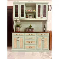 This beautiful hutch cabinet is a perfect example of farmhouse-inspired design. It features a soft green finish, glass and rattan-paneled doors, and a multitude of drawers and cabinets for storing crockery and dining essentials.