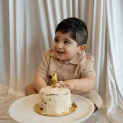 That happy smile just before the smashing begins! This shot captures the anticipation and excitement of a first birthday cake smash.