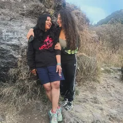 A candid moment of friendship and support between two participants on a mountain trail. Our retreats foster a safe space for genuine connection and shared experiences.