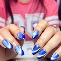This vibrant blue cat eye effect is a total showstopper. Using magnetic polish on perfectly shaped almond extensions, I create a deep, shifting glow that catches the light from every angle for a mesmerizing, high-shine finish.