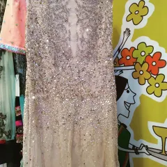 A close-up view of a heavily embellished gown, covered in sparkling sequins and crystals. This is the kind of couture detail you can find on our sale pieces, perfect for making a statement at a reception.