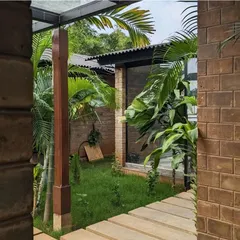 A view into a private courtyard where a stone path cuts through a small lawn. The combination of brick, stone, and turf creates a space that is both structured and soft.