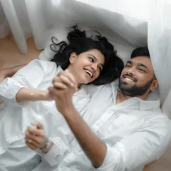 A quiet, candid moment shared between a couple during their indoor pre-wedding session. The focus here is on their natural interaction and the comfortable silence they share.