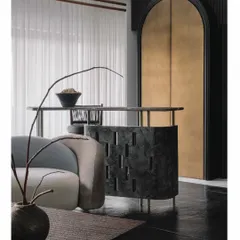 The informal bar in the 'Aria' living room is a crucial centerpiece. We designed it with a unique perforated pattern in dark stone, making it a sculptural element that overlooks the main seating area and connects the room.