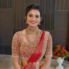 A smiling close-up of the daughter in a traditional half saree, with fresh, glowing makeup.