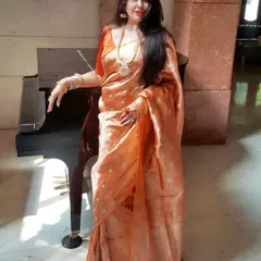 A full-length view of the stunning orange trousseau saree. The way the fabric drapes is incredibly flattering, and when paired with the right jewellery, it creates an unforgettable, regal look.