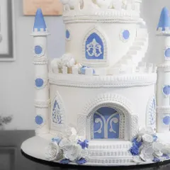 A closer look at the detailed entrance of the castle cake, featuring ornate doors and delicate sugar flowers.