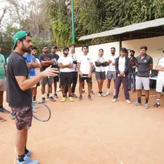 Here I am, addressing a group of players and coaches on the court. My approach is hands on and direct. I believe in creating an environment where players are challenged to think and grow.