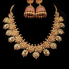 A classic temple jewellery set in an antique gold finish. The necklace features Goddess Lakshmi coin motifs, and it comes with perfectly matching jhumka earrings for a traditional look.