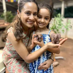 There is a special kind of magic when a parent and child create together. Here, a mother and daughter proudly show the little clay elephants they sculpted during a weekend family workshop.